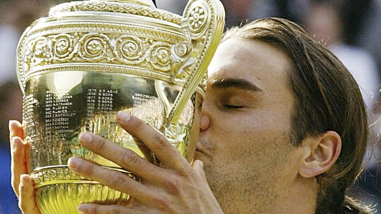 Roger Federer kisses the winner's trophy after winning the Men's Singles final on the Centre Court ...