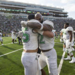 
              Marshall's Owen Porter, left, and Koby Cumberlander, right, celebrate after the team defeated Notre Dame in an NCAA college football game Saturday, Sept. 10, 2022, in South Bend, Ind. Marshall won 26-21. (Sholten Singer/The Herald-Dispatch via AP)
            