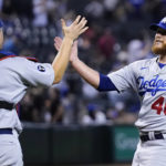 Los Angeles Dodgers relief pitcher Craig Kimbrel (46) slaps hands with catcher Will Smith after the final out of the team's baseball game against the Arizona Diamondbacks in Phoenix, Tuesday, Sept. 13, 2022. The Dodgers won 4-0 to clinch the National League West. (AP Photo/Ross D. Franklin)