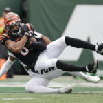 Cincinnati Bengals wide receiver Tyler Boyd (83) is tackled by New York Jets' Michael Carter II in the end zone for a touchdown during the first half of an NFL football game Sunday, Sept. 25, 2022, in East Rutherford, N.J. (AP Photo/Adam Hunger)