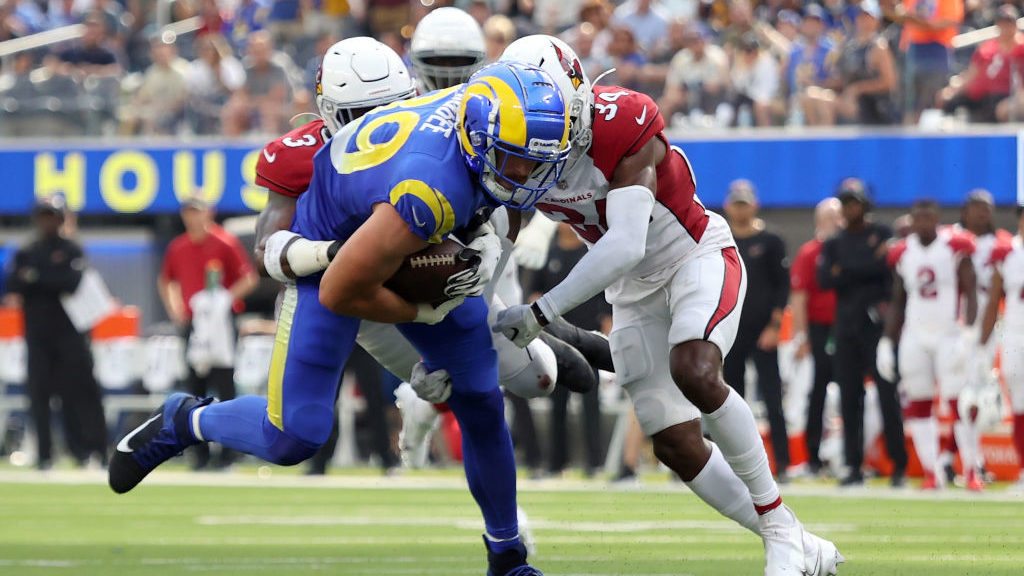Budda Baker #3 and Jalen Thompson #34 of the Arizona Cardinals tackle Tyler Higbee #89 of the Los A...