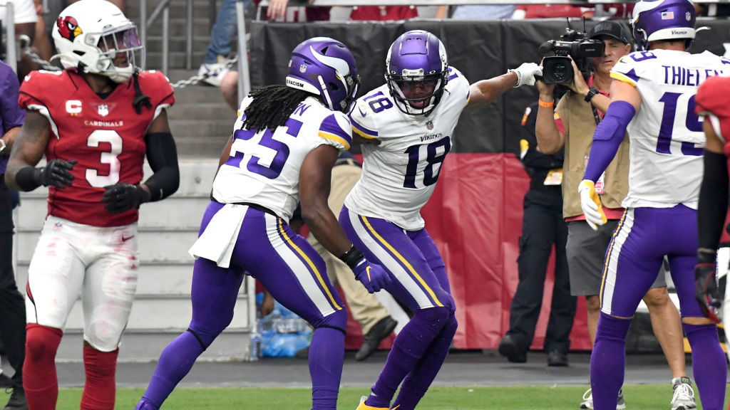 Justin Jefferson #18 of the Minnesota Vikings celebrates with Alexander Mattison #25 after catching...