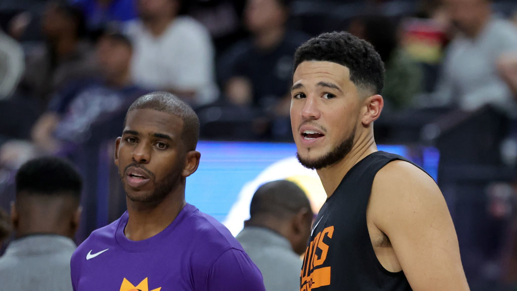 Chris Paul (L) #3 and Devin Booker #1 of the Phoenix Suns talk on the sideline in the fourth quarte...