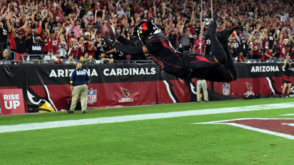 Marco Wilson #20 of the Arizona Cardinals dives into the end zone for a touchdown after interceptin...