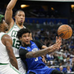 
              Orlando Magic's Chuma Okeke, right, passes the ball as he gets caught between Boston Celtics' Marcus Smart (36) and Grant Williams (12) during the second half of an NBA basketball game, Saturday, Oct. 22, 2022, in Orlando, Fla. (AP Photo/John Raoux)
            