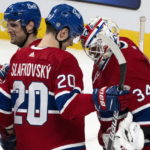 Montreal Canadiens' Juraj Slafkovsky, right, and goaltender Jake Allen celebrate their victory over the Arizona Coyotes in NHL hockey game action in Montreal, Thursday, Oct. 20, 2022. (Paul Chiasson/The Canadian Press via AP)