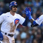Chicago Cubs' Zach McKinstry, left, celebrates with teammate Franmil Reyes, right, after scoring on an Ian Happ walk during the first inning of a baseball game against the Cincinnati Reds, Sunday, Oct. 2, 2022, in Chicago. (AP Photo/Paul Beaty)