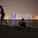 
              In this Nov. 2, 2018 picture, men fish, backdropped by the city skyline Doha, Qatar. A former CIA officer who spied on Qatar’s rivals to help the tiny Arab country land this year’s World Cup is now under FBI scrutiny and newly obtained documents show he offered clandestine services that went beyond soccer to try to influence U.S. policy, (AP Photo/Vadim Ghirda)
            