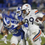 Virginia's Keytaon Thompson (99) carries the ball past Duke's Cam Dillon (35) during the first half of an NCAA college football game in Durham, N.C., Saturday, Oct. 1, 2022. (AP Photo/Ben McKeown)