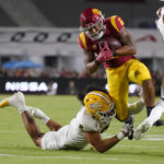 Southern California running back Austin Jones (6) breaks a tackle by Arizona State linebacker Merlin Robertson (8) during the first half of an NCAA college football game Saturday, Oct. 1, 2022, in Los Angeles. (AP Photo/Mark J. Terrill)