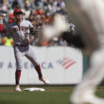 Arizona Diamondbacks second baseman Josh Rojas (10) throws to first for a double play against San Francisco Giants' David Villar, foreground, during the second inning of a baseball game in San Francisco, Saturday, Oct. 1, 2022. (AP Photo/Godofredo A. Vásquez)