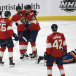 
              Florida Panthers players celebrate a goal by Eetu Luostarinen (27) as New York Islanders Noah Dobson (8) lies on the ice during the first period of an NHL hockey game, Sunday, Oct. 23, 2022, in Sunrise, Fla. (AP Photo/Michael Laughlin)
            