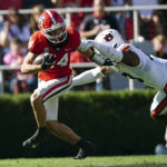 
              Georgia wide receiver Ladd McConkey (84) tries to escape from Auburn's Cam Riley (13) as he returns a punt in the first half of an NCAA college football game Saturday, Oct. 8, 2022, in Athens, Ga. (AP Photo/John Bazemore)
            