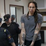 
              FILE - WNBA star and two-time Olympic gold medalist Brittney Griner is escorted from a courtroom after a hearing in Khimki just outside Moscow, Russia, on Aug. 4, 2022. A Russian court on Tuesday started hearing American basketball star Brittney Griner's appeal against her nine-year prison sentence for drug possession. (AP Photo/Alexander Zemlianichenko, File)
            
