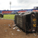 
              Police cars wrecked in soccer riots are seen on the pitch at Kanjuruhan Stadium in Malang, East Java, Indonesia, Sunday, Oct. 2, 2022. Panic at an Indonesian soccer match Saturday left over 150 people dead, most of whom were trampled to death after police fired tear gas to dispel the riots. (AP Photo/Trisnadi)
            