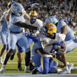 North Carolina defensive lineman Desmond Evans (10) grabs the facemask of Pittsburgh running back Israel Abanikanda (2) as he goes into the endzone for a touchdown during the first half of an NCAA college football game in Chapel Hill, N.C., Saturday, Oct. 29, 2022. Evans was called for a penalty on the play. (AP Photo/Chris Seward)