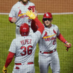 St. Louis Cardinals' Juan Yepez (36) greets Lars Nootbaar, center, and Brendan Donovan, top after they scored on a hit by Albert Pujols during the third inning of the team's baseball game against the Pittsburgh Pirates, Tuesday, Oct. 4, 2022, in Pittsburgh. (AP Photo/Keith Srakocic)