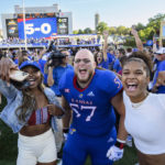Kansas offensive lineman Hank Kelly (57) and fans celebrate on the field after they beat Iowa State to go 5-0 after an NCAA college football game, Saturday, Oct. 1, 2022, in Lawrence, Kan. (AP Reed/Hoffmann)