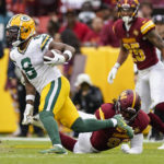 Green Bay Packers wide receiver Amari Rodgers (8) runs with the ball as he avoids Washington Washington Commanders defensive end James Smith-Williams (96) on the last play of an NFL football game Sunday, Oct. 23, 2022, in Landover, Md. (AP Photo/Patrick Semansky)
