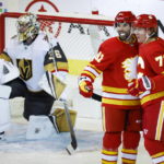 Vegas Golden Knights goalie Logan Thompson, left, looks away as Calgary Flames forward Tyler Toffoli, right, celebrates his goal with forward Nazem Kadri during the second period of an NHL hockey game Tuesday, Oct. 18, 2022, in Calgary, Alberta. (Jeff McIntosh/The Canadian Press via AP)