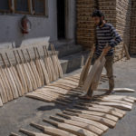 
              Imran Malik, a Kashmiri worker carries unfinished cricket bats made out of willow at a factory in Awantipora, south of Srinagar, Indian controlled Kashmir, Sept. 22, 2022. Kashmir’s dwindling willow plantations are impacting the region’s famed cricket bat industry and risking the supply of cricket bats in India, where the sport is hugely followed. The industry employs more than 10,000 people and manufactures nearly a million bats a year. (AP Photo/Dar Yasin)
            