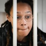 
              FILE - WNBA star and two-time Olympic gold medalist Brittney Griner speaks to her lawyers standing in a cage at a court room prior to a hearing, in Khimki just outside Moscow, Russia, Tuesday, July 26, 2022. A Russian court has on Tuesday, Oct. 23 started hearing American basketball star Brittney Griner's appeal against her nine-year prison sentence for drug possession. (AP Photo/Alexander Zemlianichenko, Pool, File)
            