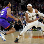 New Orleans Pelicans guard Devonte' Graham (4) looks to pass as Phoenix Suns guard Cameron Payne (15) defends during the first half of an NBA basketball game, Friday, Oct. 28, 2022, in Phoenix. (AP Photo/Matt York)