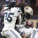 
              New Orleans Saints running back Alvin Kamara fumbles the ball after being hit by Seattle Seahawks cornerback Coby Bryant (8) and safety Ryan Neal during an NFL football game in New Orleans, Sunday, Oct. 9, 2022. Kamara's fumble led to a Seattle Seahawks touchdown. (AP Photo/Gerald Herbert)
            