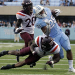 North Carolina running back Omarion Hampton (28) gets hit by Virginia Tech defensive back Chamarri Conner (1) and defensive back DJ Harvey (20) during the second half of an NCAA college football game in Chapel Hill, N.C., Saturday, Oct. 1, 2022. (AP Photo/Chris Seward)