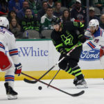 Dallas Stars center Tyler Seguin (91) tries to get the puck past New York Rangers defenseman Jacob Trouba (8) and defenseman K'Andre Miller (79) during the first period of an NHL hockey game in Dallas, Saturday, Oct. 29, 2022. (AP Photo/Michael Ainsworth)