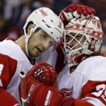 Detroit Red Wings goaltender Alex Nedeljkovic (39) and Ben Chiarot celebrate after the third period of an NHL hockey game against the New Jersey Devils Saturday, Oct. 15, 2022, in Newark, N.J. The Red Wings won 5-2. (AP Photo/Adam Hunger)