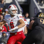 Wisconsin quarterback Graham Mertz (5) looks to pass the ball against Northwestern defensive lineman Sean McLaughlin (97) during the first half of an NCAA college football game on Saturday, Oct. 8, 2022, in Evanston, Ill. (AP Photo/Kamil Krzaczynski)