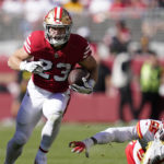 
              San Francisco 49ers running back Christian McCaffrey (23) runs in front of Kansas City Chiefs defensive end Frank Clark (55) during the first half of an NFL football game in Santa Clara, Calif., Sunday, Oct. 23, 2022. (AP Photo/Godofredo A. Vásquez)
            