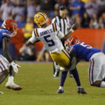 
              LSU quarterback Jayden Daniels (5) is stopped by Florida safety Kamari Wilson, right, and linebacker Brenton Cox Jr., left, as he tries to run from the pocket during the first half of an NCAA college football game, Saturday, Oct. 15, 2022, in Gainesville, Fla. (AP Photo/John Raoux)
            