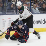 Arizona Coyotes' Nick Ritchie, top, pushes Columbus Blue Jackets' Andrew Peeke to the ice during the third period of an NHL hockey game Tuesday, Oct. 25, 2022, in Columbus, Ohio. (AP Photo/Jay LaPrete)