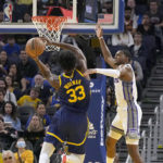 Golden State Warriors center James Wiseman (33) drives to the basket against Sacramento Kings guard De'Aaron Fox, right, during the first half of an NBA basketball game on Sunday, Oct. 23, 2022 in San Francisco. (AP Photo/ Tony Avelar)
