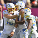 
              Los Angeles Chargers running back Austin Ekeler (30) is congratulated by quarterback Justin Herbert (10) after running in for a touchdown against the Cleveland Browns during the second half of an NFL football game, Sunday, Oct. 9, 2022, in Cleveland. Offensive tackle Trey Pipkins III is at center. (AP Photo/David Richard)
            
