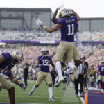 Washington wide receiver Jalen McMillan (11) leaps in the air as he celebrates his touchdown with other team members against Arizona during the first half on an NCAA football game, Saturday, Oct. 15, 2022, in Seattle. (AP Photo/John Froschauer)