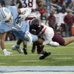 North Carolina tight end Bryson Nesbit (18) drags Virginia Tech defensive back Cam Johnson (12) into the end zone as he scores a touchdown during the second half of an NCAA college football game in Chapel Hill, N.C., Saturday, Oct. 1, 2022. (AP Photo/Chris Seward)