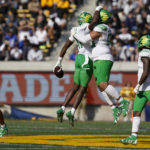 Oregon defensive back Trikweze Bridges (11) celebrates with defensive tackle Keyon Ware-Hudson (95) after intercepting a pass against California during the first half of an NCAA college football game in Berkeley, Calif., Saturday, Oct. 29, 2022. (AP Photo/Godofredo A. Vásquez)