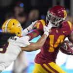 Southern California running back Raleek Brown, right, has his face mask grabbed by Arizona State linebacker Merlin Robertson as he runs the ball during the first half of an NCAA college football game Saturday, Oct. 1, 2022, in Los Angeles. (AP Photo/Mark J. Terrill)