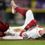 Cincinnati Reds' TJ Friedl is injured while attempting to steal third base during the third inning of a baseball game against the Chicago Cubs, Monday, Oct. 3, 2022, in Cincinnati. (AP Photo/Jeff Dean)