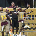 Arizona State defensive back Jordan Clark (1) celebrates after his interception for a touchdown against Washington as Arizona State defensive back Khoury Bethley (15) and linebacker Merlin Robertson (8) follow during the first half of an NCAA college football game in Tempe, Ariz., Saturday, Oct. 8, 2022. (AP Photo/Ross D. Franklin)