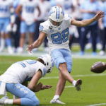 
              North Carolina place kicker Noah Burnette (98) kicks an extra point as punter Cole Maynard (92) holds during the first half of an NCAA college football game against Miami, Saturday, Oct. 8, 2022, in Miami Gardens, Fla. (AP Photo/Wilfredo Lee)
            
