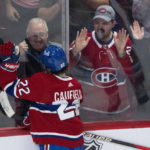 Montreal Canadiens' Cole Caufield celebrates after his goal against Arizona Coyotes goaltender Connor Ingram with fans during first-period NHL hockey game action in Montreal, Thursday, Oct. 20, 2022. (Paul Chiasson/The Canadian Press via AP)