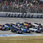 Ross Chastain (1) leads a pack of cars to through the Tai-Oval during a NASCAR Cup Series auto race Sunday, Oct. 2, 2022, in Talladega, Ala. (AP Photo/Butch Dill)