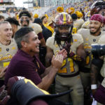 
              Arizona State interim head coach Shaun Aguano, front left, celebrates with players, including RJ Regan (21), after an NCAA college football game against Washington in Tempe, Ariz., Saturday, Oct. 8, 2022. (AP Photo/Ross D. Franklin)
            