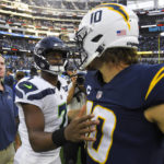 
              Seattle Seahawks quarterback Geno Smith (70) greets Los Angeles Chargers quarterback Justin Herbert (10) after their NFL football game Sunday, Oct. 23, 2022, in Inglewood, Calif. The Seahawks won 37-23. (AP Photo/Mark J. Terrill)
            