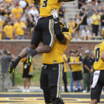 Missouri's Javon Foster, bottom, lifts teammate Missouri's Luther Burden III after Burden scored a touchdown during the first quarter of an NCAA college football game against Vanderbilt, Saturday, Oct. 22, 2022, in Columbia, Mo. (AP Photo/L.G. Patterson)