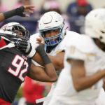Jackson State defensive lineman Justin Ragin (92) is held by a Southern offensive lineman as he tries to tackle Southern University quarterback Besean McCray during the first half of an NCAA college football game in Jackson, Miss., Saturday, Oct. 29, 2022. (AP Photo/Rogelio V. Solis)